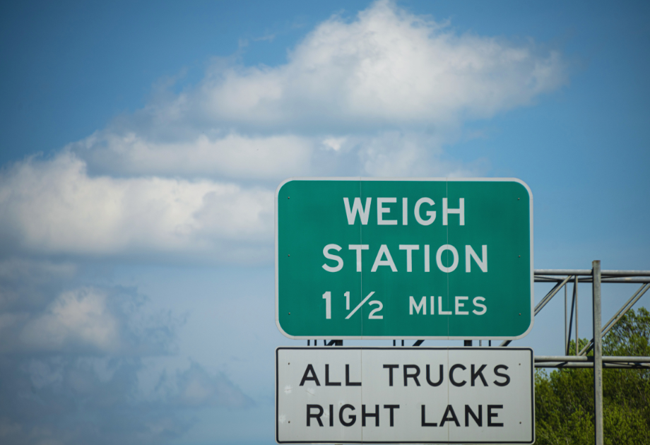 Highway sign directing trucks to a weigh station 1½ miles ahead.
